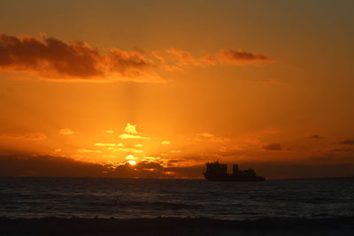 Silhouette ship sailing on sea against sky during sunset