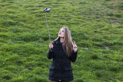 Full length of teenage girl standing on green grass
