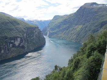 Scenic view of waterfall by sea against sky