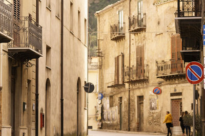 Road sign on street by buildings in city