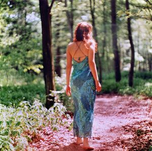 Full length of woman standing on tree trunk in forest