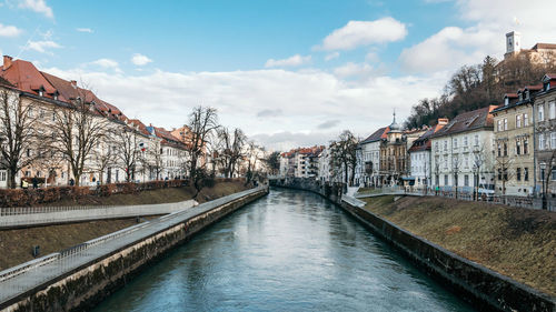 Bridge over river amidst buildings against sky