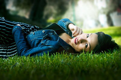 Portrait of young woman lying on grass