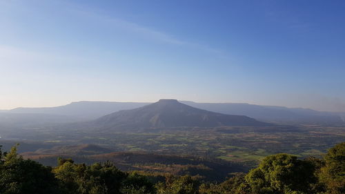 Scenic view of landscape and mountains against blue sky