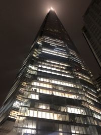 Low angle view of illuminated buildings against sky at night