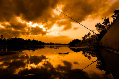 Scenic view of lake against orange sky