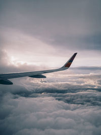 Airplane flying over cloudscape against sky