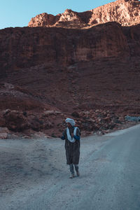 Rear view of man walking on rock