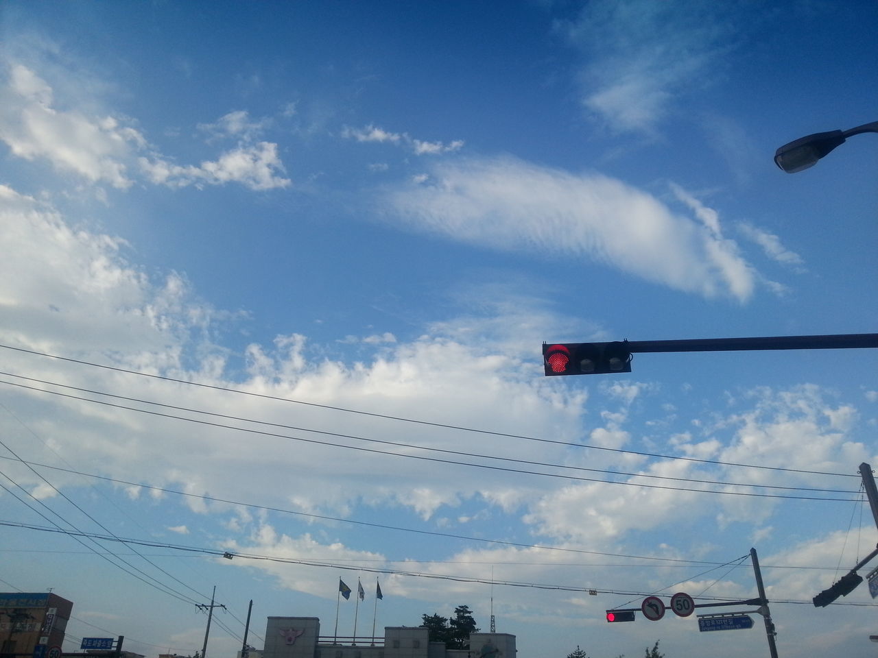 transportation, low angle view, sky, mode of transport, flying, airplane, air vehicle, cloud - sky, car, built structure, public transportation, travel, street light, cloud, day, outdoors, architecture, on the move, no people, road signal