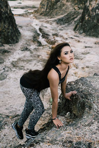 Portrait of beautiful young woman on rock