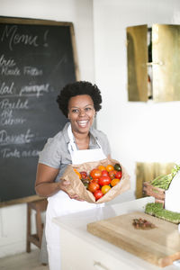 Smiling woman holding tomatoes