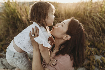 Side view of mother close wtih young toddler at beach