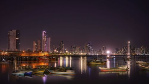 Illuminated modern buildings against sky at night