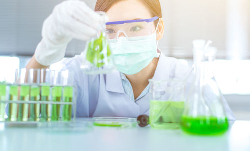 Female scientist performing experiment at table in laboratory