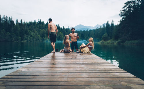 People on lake against sky