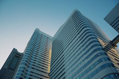 Low angle view of modern buildings against clear blue sky