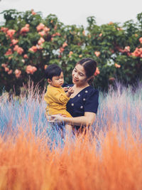 Side view of woman picking flowers on field