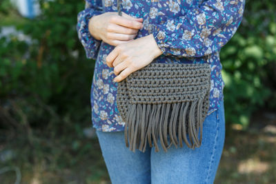 Midsection of woman carrying purse