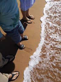 Low section of family standing at shore