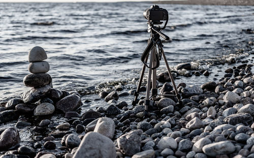 Nikon camera with tripod on a stone beach at sunset over the swedish baltic