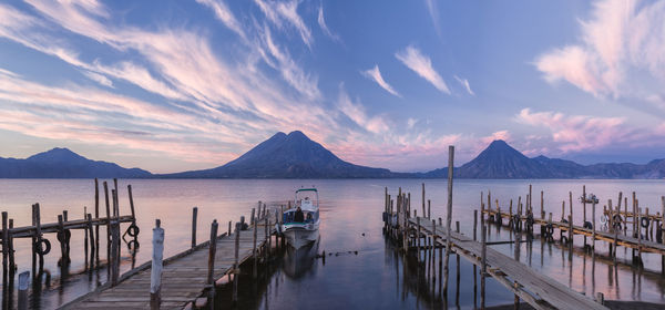 Panoramic view of wooden posts in sea against sky