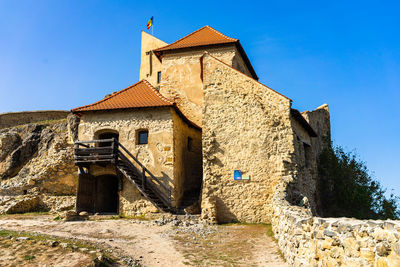 Low angle view of old building against clear blue sky