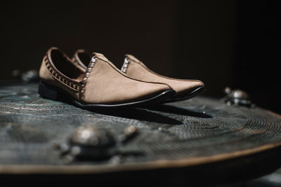 Close-up of shoes on table against black background