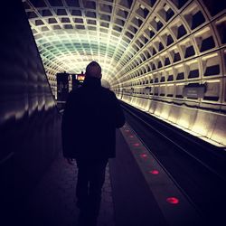 Rear view of man standing in tunnel