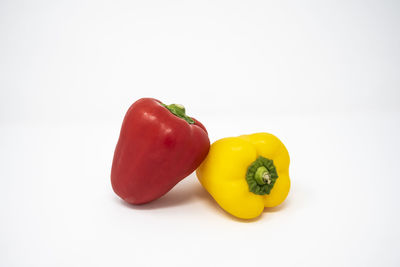 Close-up of yellow bell peppers against white background