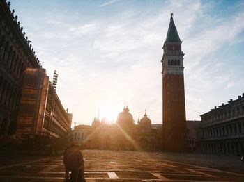 Rear view of man sitting at st marks square during sunny day