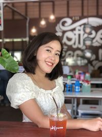 Portrait of a smiling young woman with drink