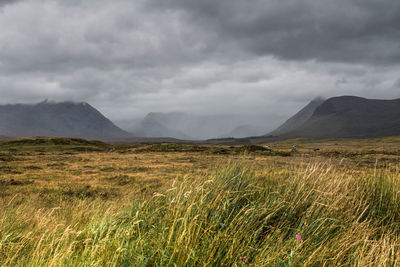 View of countryside landscape against cloudy sky