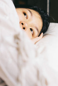 Portrait of woman lying down on bed