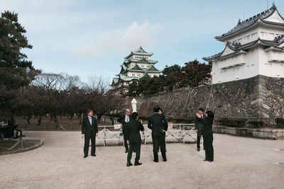 People standing by traditional building against sky