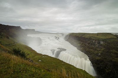 Scenic view of waterfall against sky