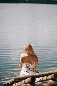 Woman sitting by lake