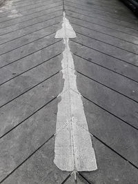 High angle view of arrow symbol on footpath