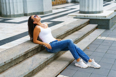 Woman looking away while sitting on staircase