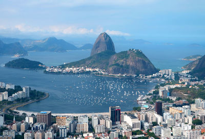 High angle view of city by sea against sky