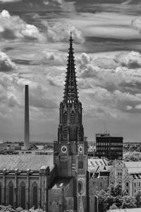 Buildings in city against cloudy sky