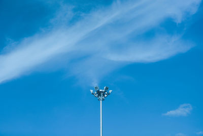 Low angle view of floodlight against blue sky