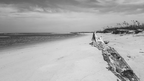 Scenic view of beach against cloudy sky