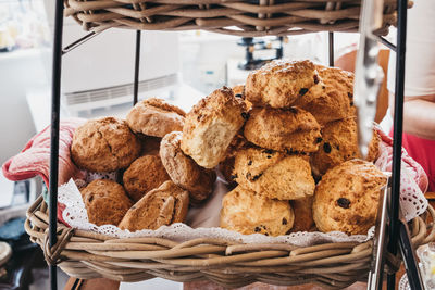 View from above of freshly baked fruit scones in a basket, selective focus.