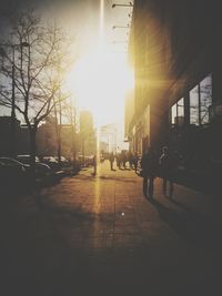 Silhouette people walking on street amidst buildings in city