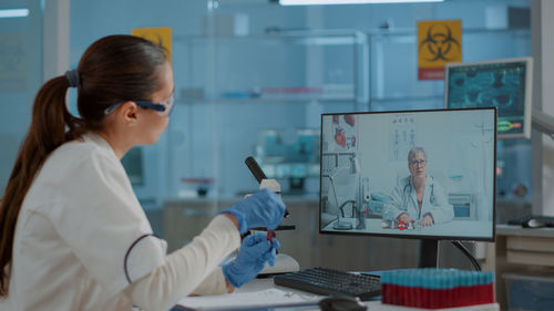 Female scientist talking on video call at laboratory