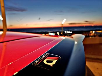 Close-up of illuminated car against sky during sunset