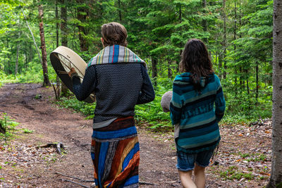 Rear view of people walking in forest