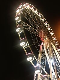 Low angle view of illuminated ferris wheel against sky at night