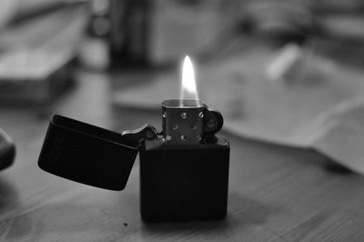 Close-up of illuminated cigarette lighter on table