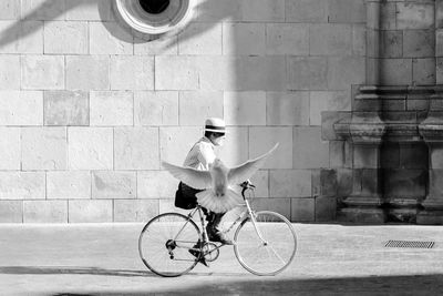 Man with bicycle on road in city